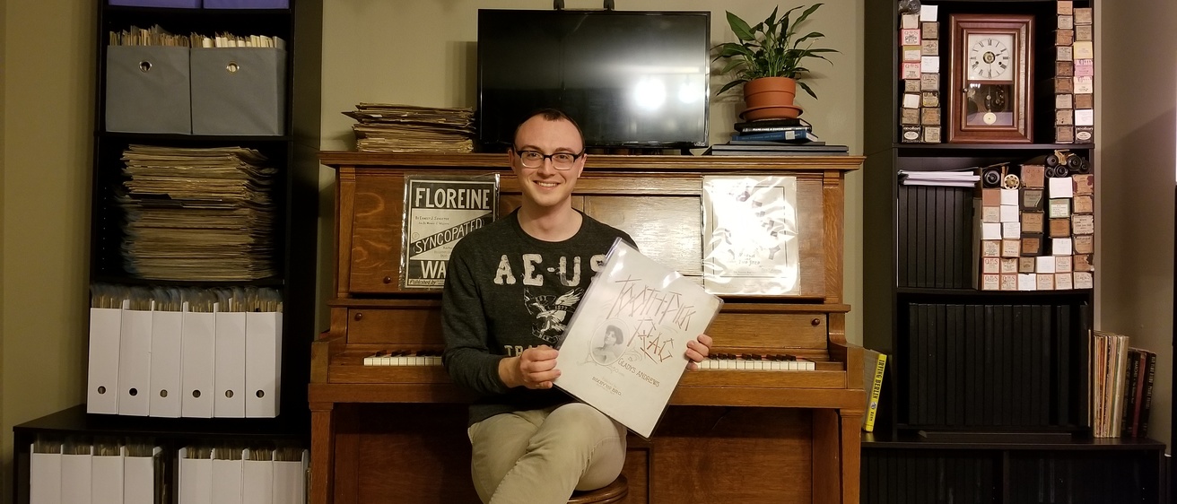 Colton Neely sits with his piano and extensive collection of sheet-ography and recorded music spanning the Golden Era of Ragtime